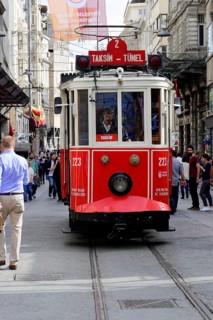 Historic tram Nostaljik Tramvay travelling through Istiklal Caddesi shopping street, Beyoglu,