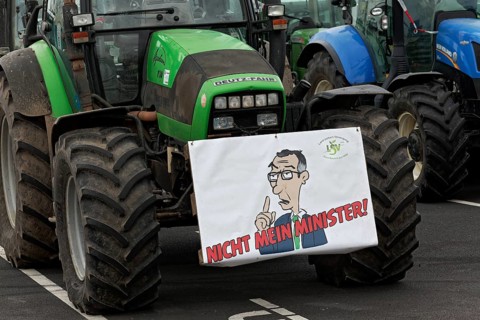 Sign with drawn Minister of Agriculture Cem Oezdemir on a tractor, farmer protests, demonstration