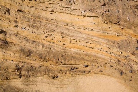 Pleistocene ice age outwash deposits in sedimentary Red Crag rock strata of cliff face, Suffolk