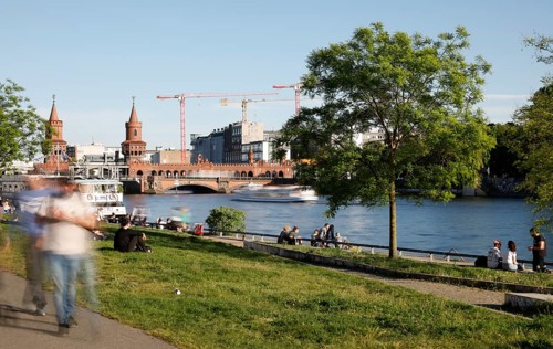 Long exposure shows walkers and people on the banks of the Spree, Berlin, 05/05/2018