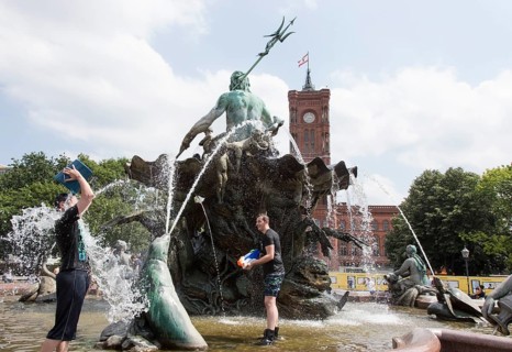 Water-hungry participants of this year's water fight at Berlin's Neptune Fountain cool off in