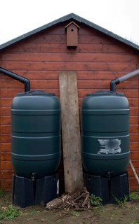 Two water butts illustrating concept of watershed dividing drainage basins on roof