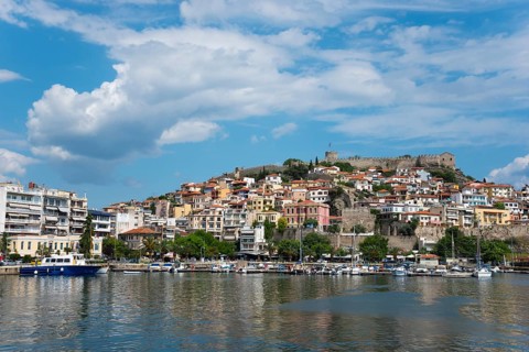 View of a Mediterranean coastal town with a fortress on a hill and boats at the pier, Old Town,