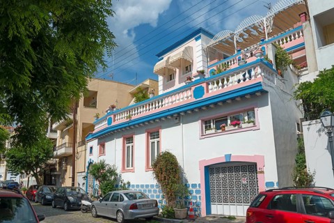 Colourful house with blue tiles and decorations on a busy street in the old town, Kavala, Dimos