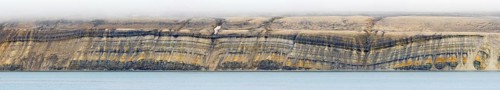 Sea cliff showing limestone and sandstone strata from the Permian period along the Hinlopen Strait,