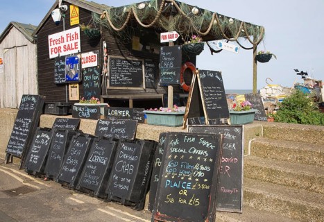 Blackboard offers for fresh fish on sale outside beach shed, Aldeburgh, Suffolk, England, United