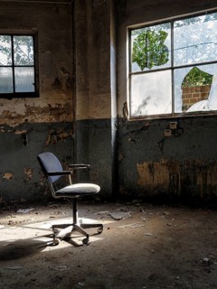 Single swivel chair, office chair in an empty dilapidated factory building, peeling paint,