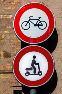Old town signs against bicycles and e-scooters, Grado Island, north coast of the Adriatic, Friuli,