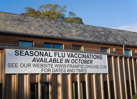 Seasonal flu vaccinations available poster sign on Framfield health centre, Woodbridge, Suffolk,