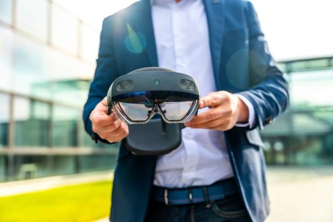 Cropped photo with close-up of the hands of a businessman holding a innovative augmented vision