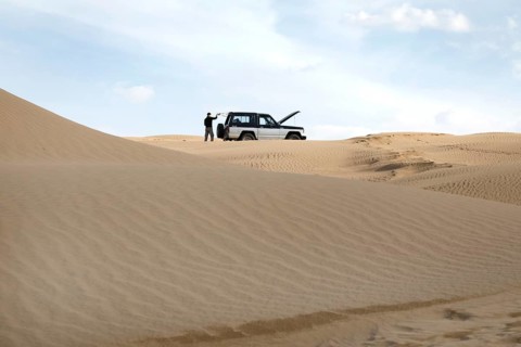 Symbolic image of car breakdown with Nissan Patrol off-road vehicle in the Mesr Desert, Iran. The