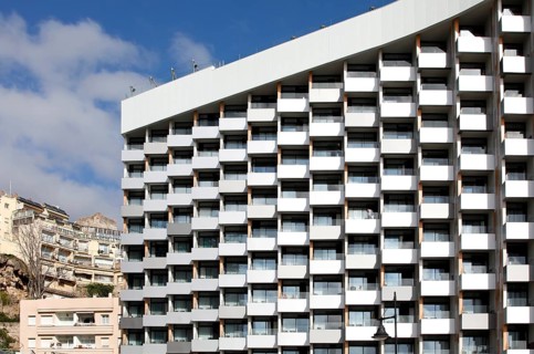 A high-rise hotel stands next to two small old hotels on the beach in Torremolinos, Spain, Costa