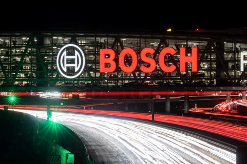 A8 motorway at Stuttgart Airport with Bosch multi-storey car park in the evening, cars create light