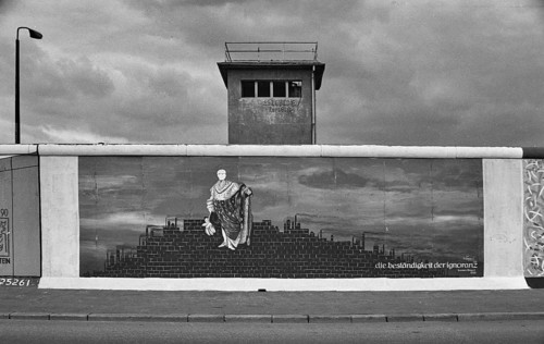Painting Die Bestaendigkeit der Ignoranz by Karsten Wenzel, behind it a former watchtower of the