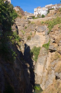 El Tajo canyon of the Rio Guadalevin river with white buildings perched on the cliff top, Ronda,