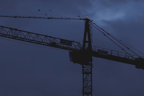 A crane works at blue hour in Berlin, 20/02/2024