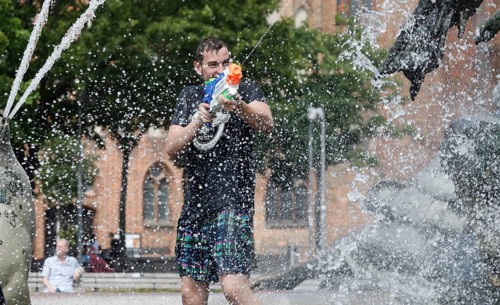 Participants in the annual water fight at Berlin's Neptune Fountain cool off in summer