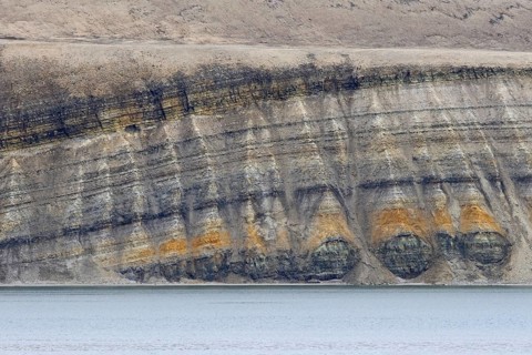 Sea cliff showing limestone and sandstone strata from the Permian period along the Hinlopen Strait,