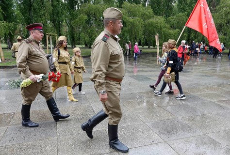 Men in Russian uniforms walk to the Russian memorial in Treptower Park in Berlin on the 74th