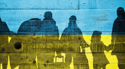 Ukrainian flag painted on a concrete wall with Ukrainian refugees