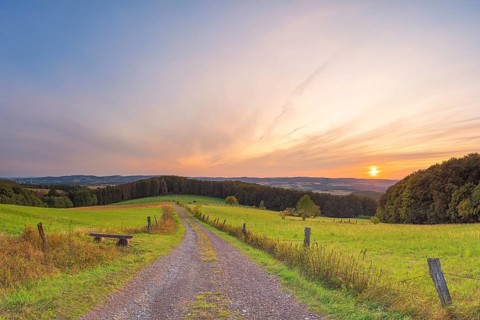 A small bench stands at the edge of the path with a view of the Weserbergland, landscape format,