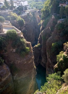 El Tajo canyon of the Rio Guadalevin river with white buildings perched on the cliff top, Ronda,