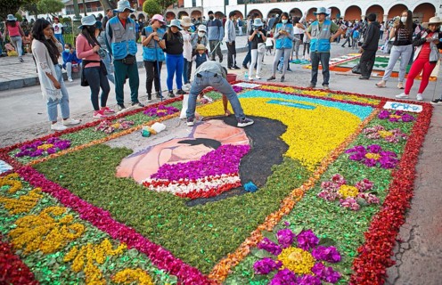 Peruvian man making a floor painting in the Plaza de Armas, spectators watching, Ayacucho, Huamanga