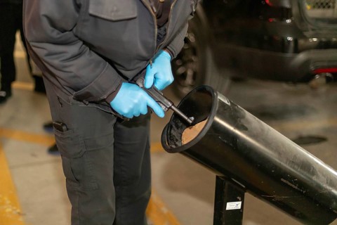 Detroit, Michigan, A police officer checks a handgun turned in at a gun buy-back event to be sure