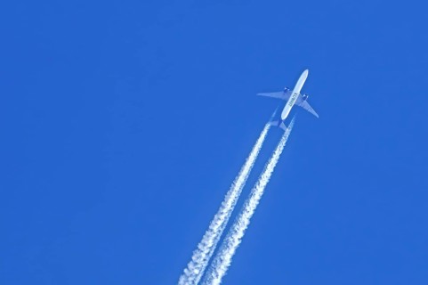 Flying twin-engine jet airliner, aircraft, plane from the airline Kuwait Airways showing contrails,