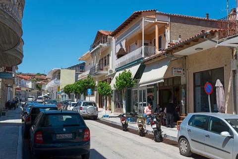 Urban street with shops, car parks and pedestrians on a sunny day, commercial street, Soufli,