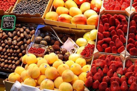 Fresh strawberries, mangoes, dates, peaches, blueberries and redcurrants at the fruit and vegetable