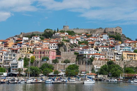 A marina with colourful houses and an ancient castle under a partly cloudy sky, fortress, old town,