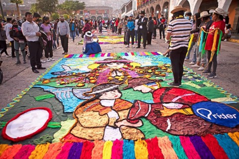 Peruvian couple making a floor painting in the Plaza de Armas, spectators watching, Ayacucho,