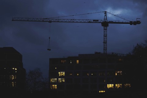 A crane works at blue hour in Berlin, 20/02/2024