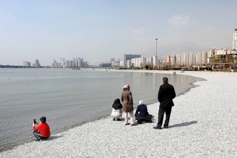 A family on the beach of Lake Chitgar in Tehran, Iran. Lake Chitgar is a man-made lake in the