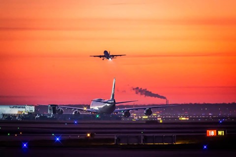 Early in the morning at the airport in front of sunrise, a Boeing 747 aircraft stands ready for