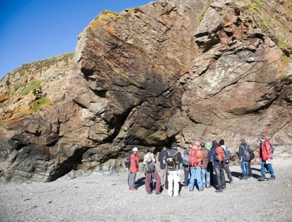 Student group of geologists on a fieldtrip at Polpeor Cove, Lizard Point, Cornwall, England, United