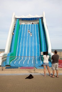 Children playing on giant inflated slide seaside attraction, Great Yarmouth, Norfolk, England