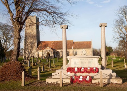 War memorial with poppy wreaths at St John the Baptists church, Snape, Suffolk, England, United