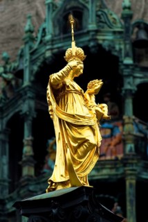 Statue of Maria Mary with Jesus in front of the Glockenspiel of New Town Hall Marienplatz, Munich,