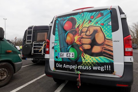Fist smashes the traffic light, placard on a van, farmers' protests, demonstration against policies