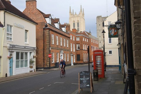 Tower of Saint Edmundsbury Cathedral above a street of historic buildings, Bury St Edmunds,
