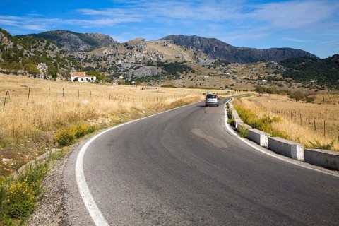 Vehicle driving around corner in rural road in Sierra de Grazalema natural park, Cadiz province,