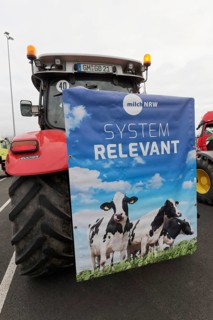 Poster with dairy cows and writing Systemrelevant on a tractor, farmer protests, demonstration