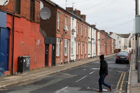 A man walks across a street near Liverpool FC's football stadium, 02/03/2019