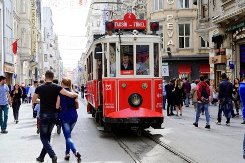 Historic tram Nostaljik Tramvay travelling through Istiklal Caddesi shopping street, Beyoglu,