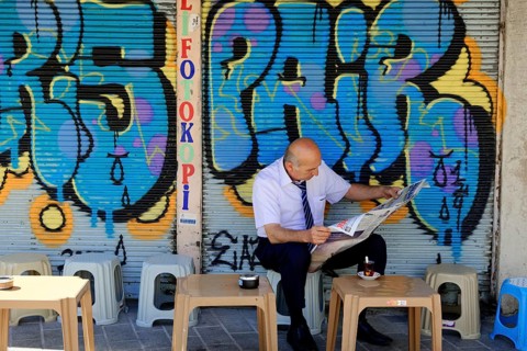 Reading newspaper, bazaar district, Eminoenue, Istanbul, European part, Istanbul province, Turkey,