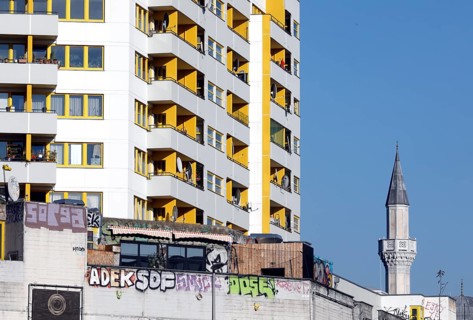 Minaret of the Mevlana mosque next to a high-rise building in Berlin's Kreuzberg district, 12