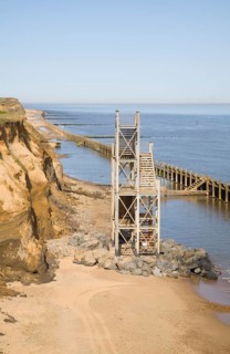 Former beach access stairs now stand alone as coastal erosion continues, Happisburgh, Norfolk,