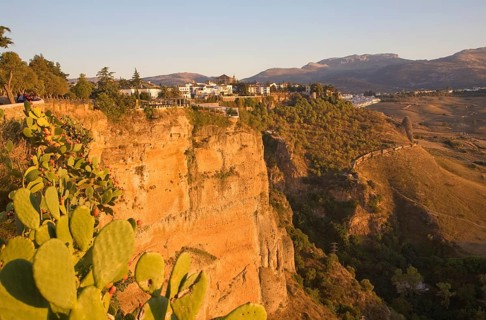 Historic buildings perched on sheer cliff top in Ronda, Spain, Europe